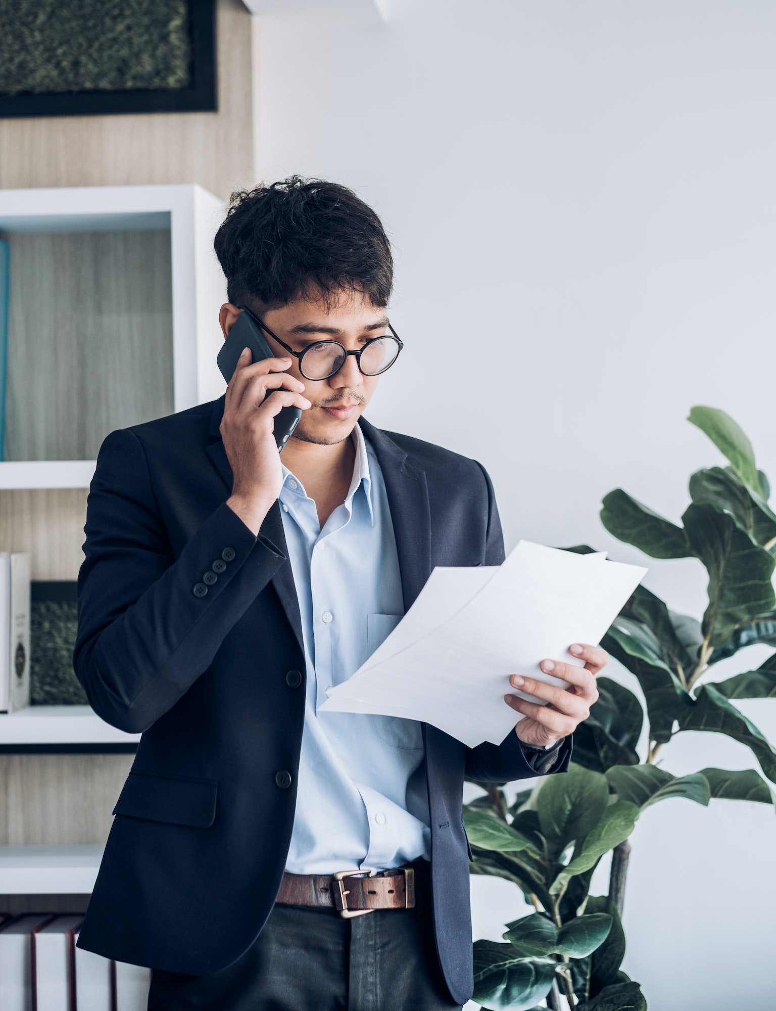 Asian businessman standing and talking on smart phone contact